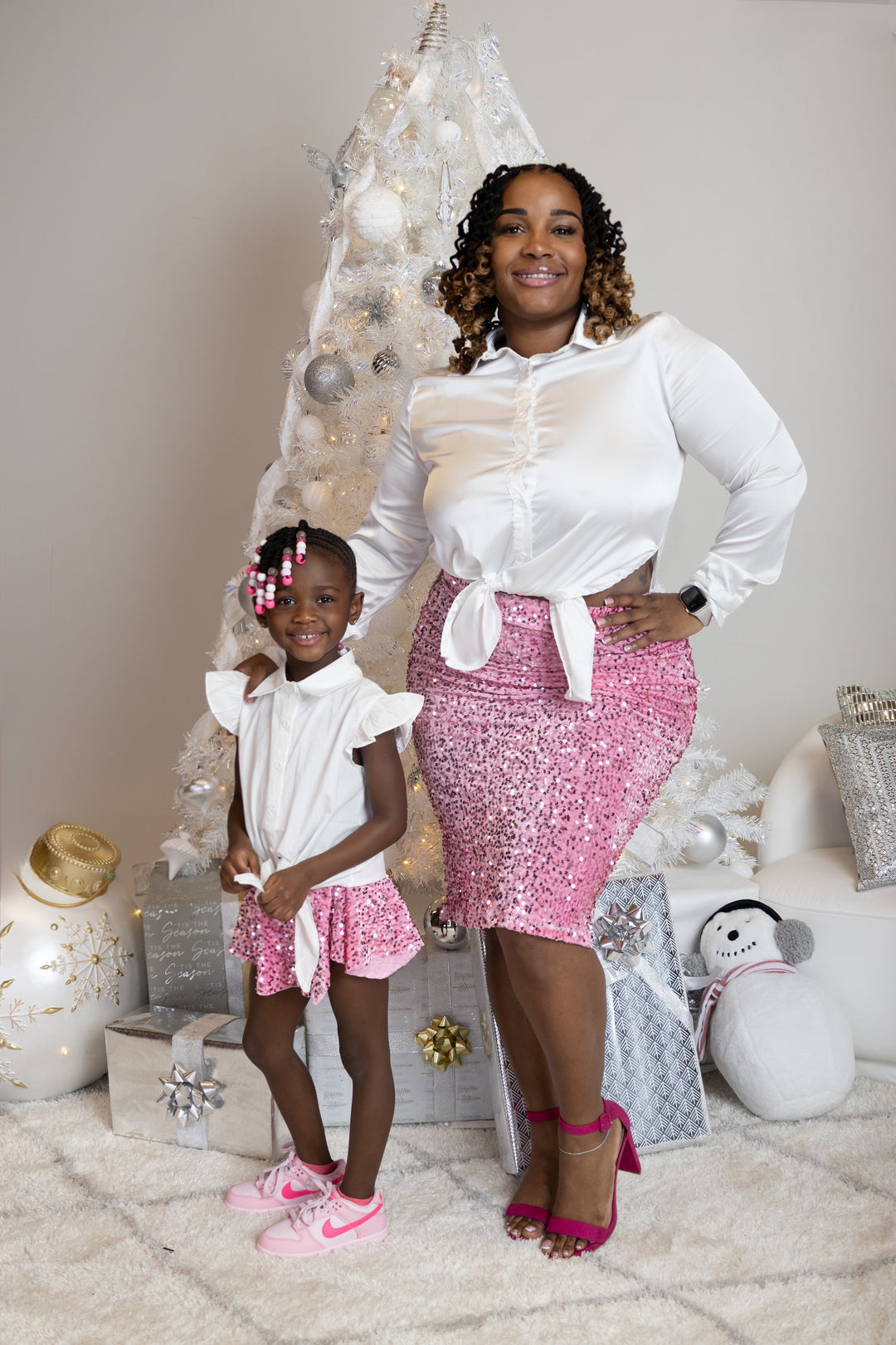 Ashley Wardlow, the lead designer and custom dressmaker behind Sewn In The Wood, standing with her daughter in matching handmade pink sequin styles.