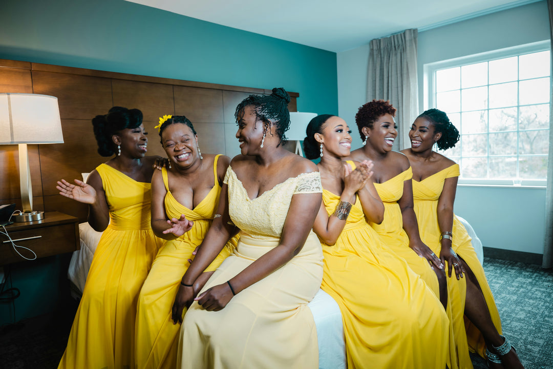 A joyful bridal party wearing elegant custom bridesmaid dresses and coordinated formal evening gowns, wedding party inspiration by Sewn In The Wood.