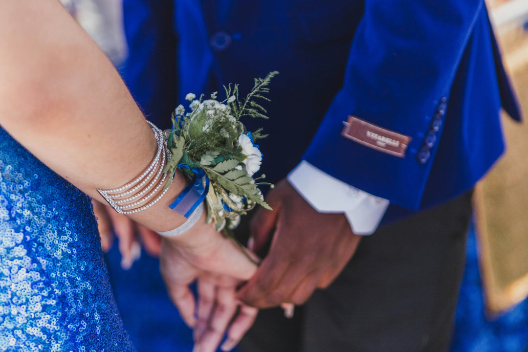 Close-up of handmade luxury formalwear details featuring a sparkling crystal statement bracelet, an elegant floral corsage, and custom eveningwear accessories by Sewn In The Wood.